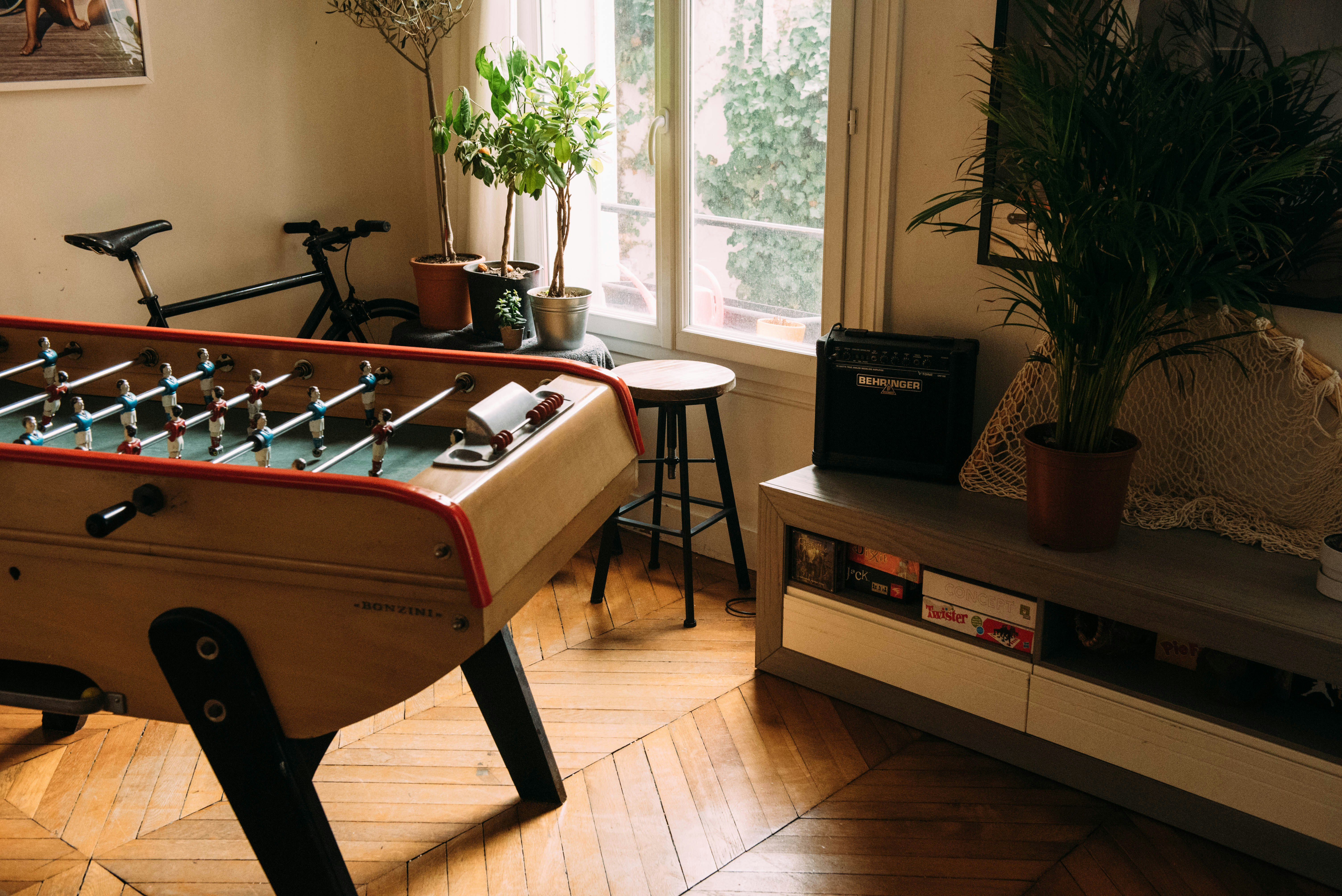 brown air hockey beside bicycle inside beige room